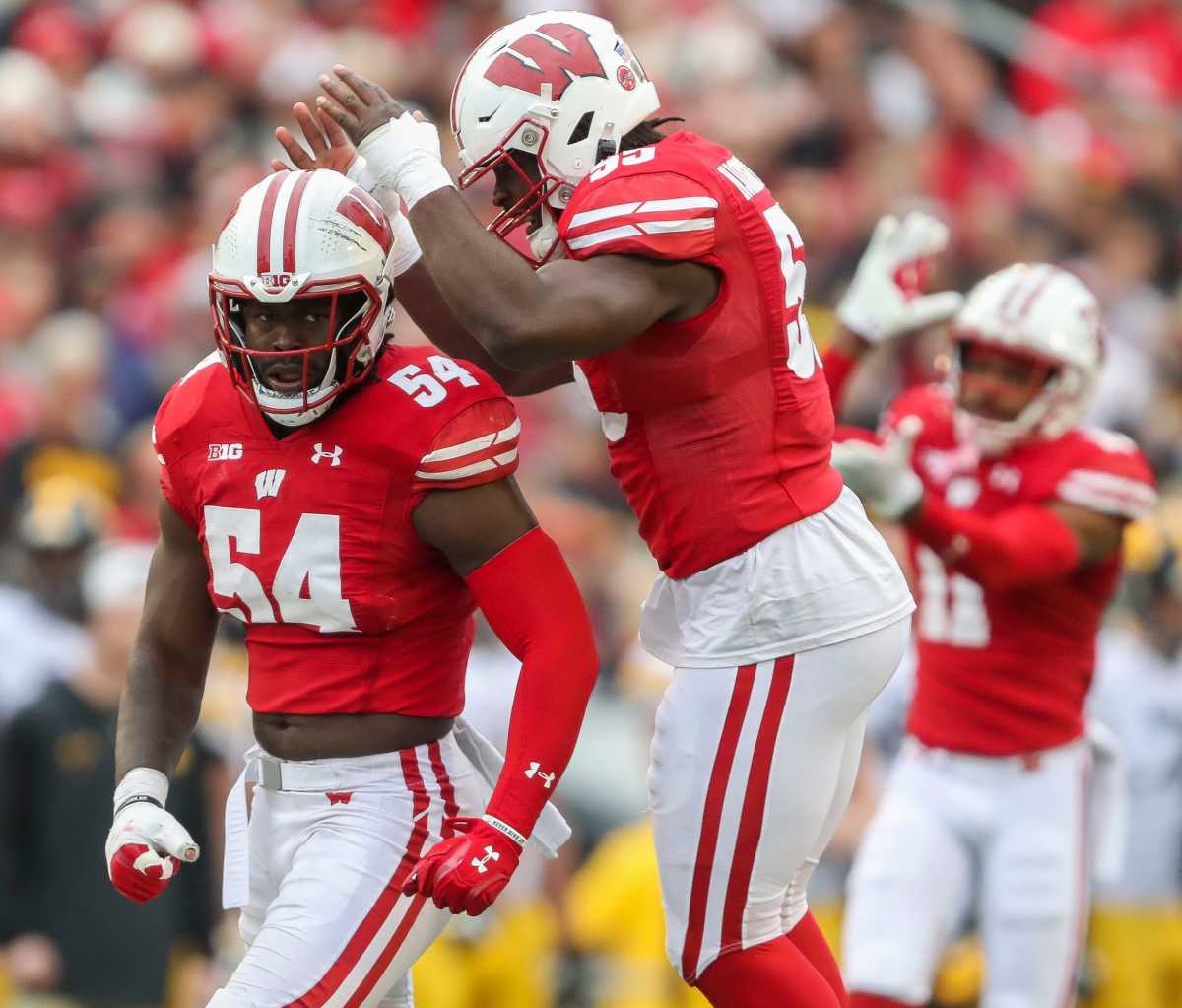 Wisconsin linebackers Jordan Turner and Maema Njongmeta (55) celebrate after Turner sacks Iowa quarterback Deacon Hill on Saturday, October 14, 2023, at Camp Randall Stadium in Madison, Wis. Iowa won the game, 12-6.