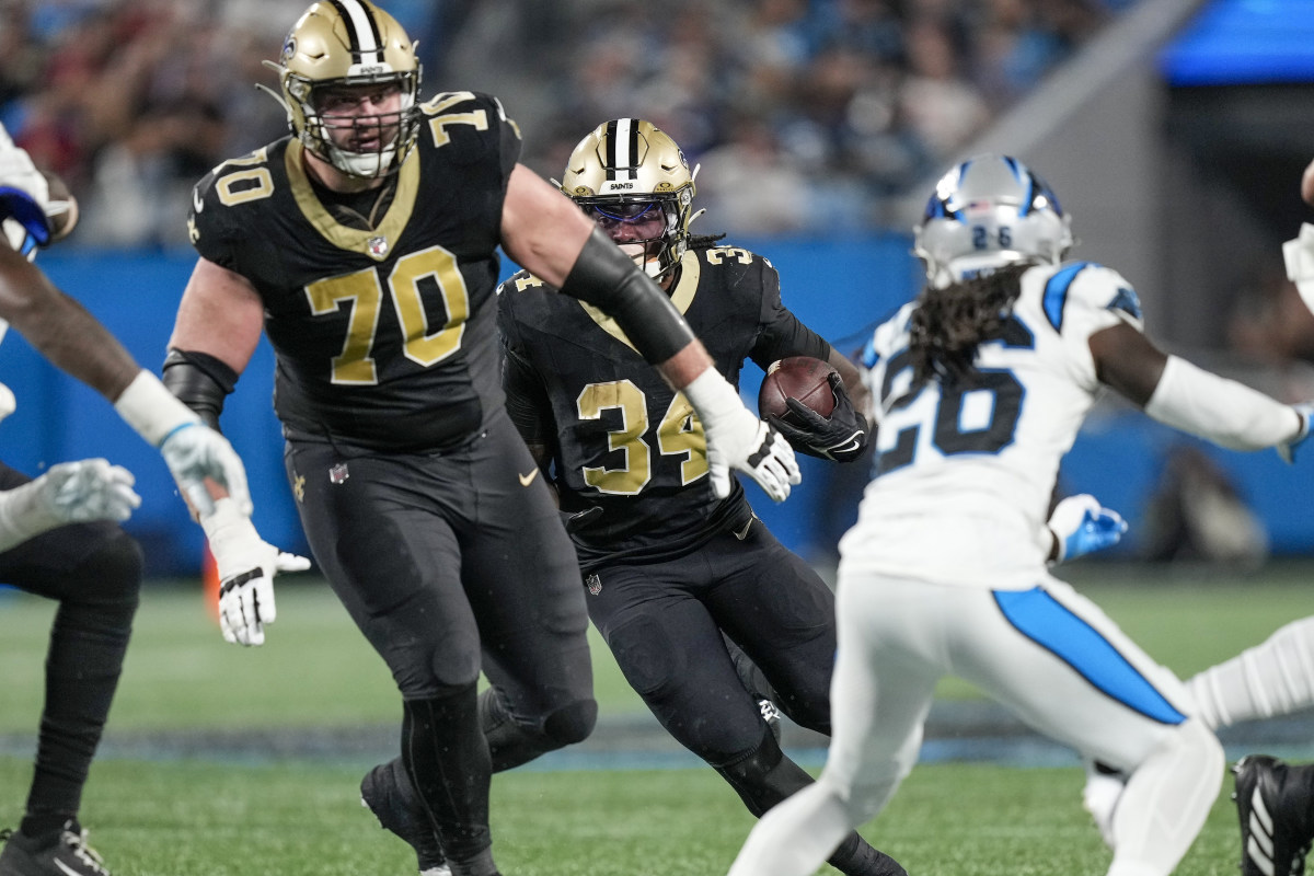 New Orleans Saints running back Tony Jones Jr. (34) follows a block by offensive tackle Trevor Penning (70)