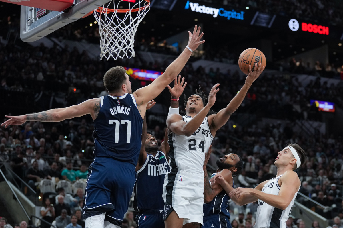 San Antonio Spurs guard Devin Vassell (24) shoots against Dallas Mavericks guard Luka Doncic (77) in the first half at the Frost Bank Center.