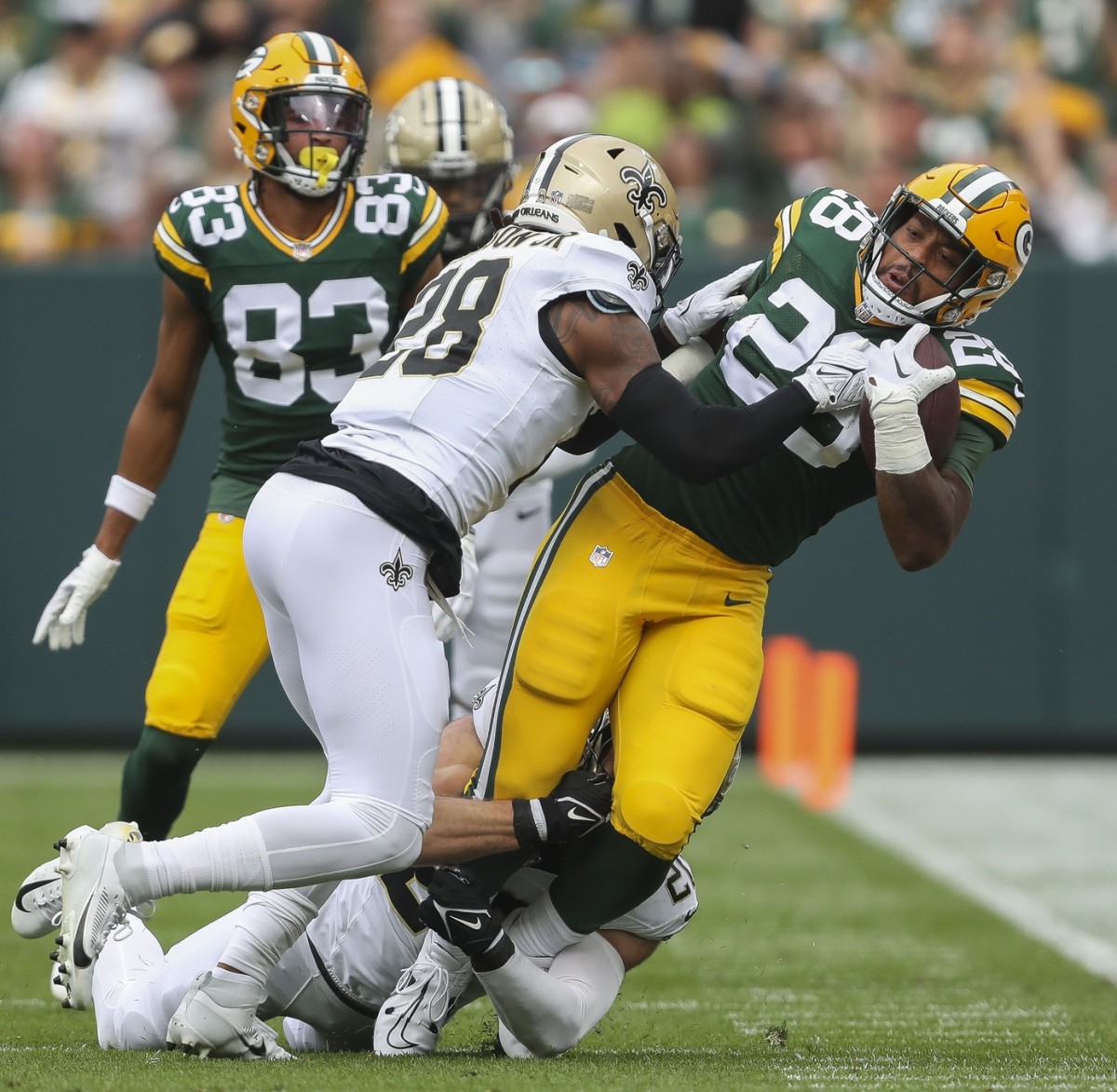 Green Bay Packers running back AJ Dillon (right) is tackled by New Orleans Saints linebacker Pete Werner (bottom) and New Orleans Saints cornerback Lonnie Johnson Jr. Mandatory Credit: Tork Mason-USA TODAY NETWORK