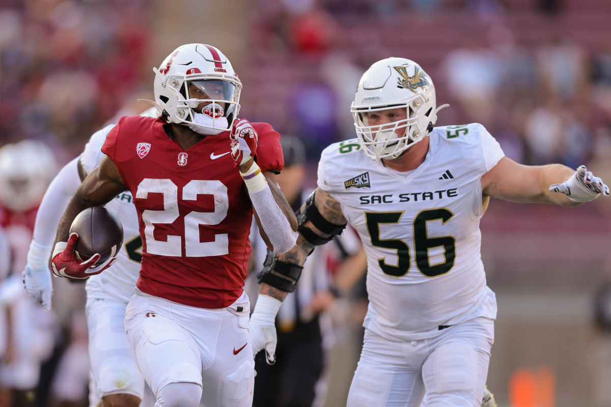 Sep 16, 2023; Stanford, California, USA; Stanford Cardinal running back E.J. Smith (22) runs with the ball past Sacramento State Hornets defensive lineman Brandon Knott (56) during the second quarter at Stanford Stadium. Mandatory Credit: Sergio Estrada-USA TODAY Sports