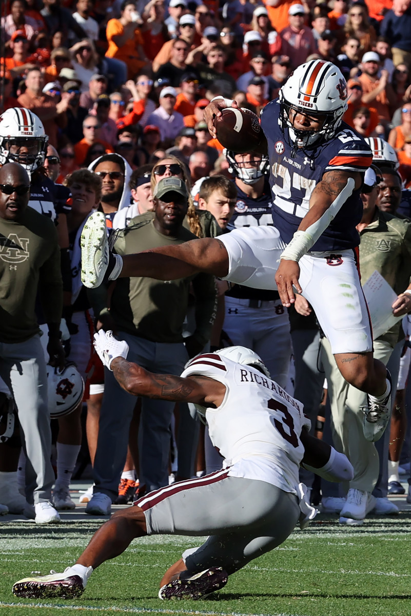 Oct 28, 2023; Auburn, Alabama, USA; Auburn Tigers running back Jarquez Hunter (27) jumps over Mississippi State Bulldogs cornerback Decamerion Richardson (3) during the second quarter at Jordan-Hare Stadium. Mandatory Credit: John Reed-USA TODAY Sports  