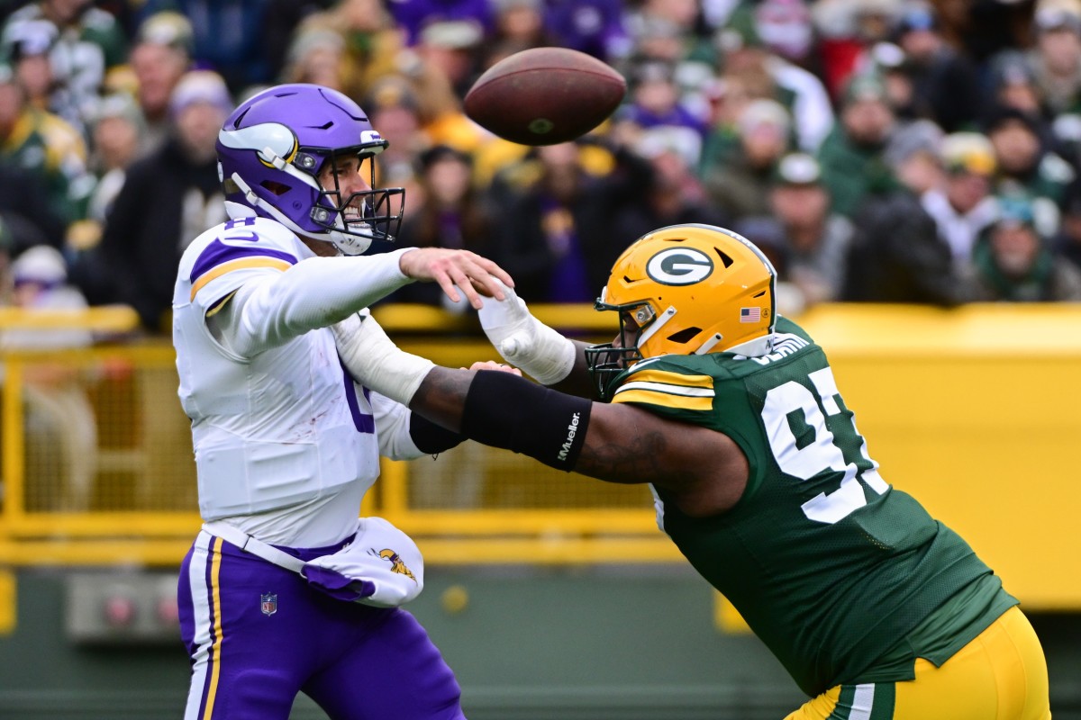 Oct 29, 2023; Green Bay, Wisconsin, USA; Minnesota Vikings quarterback Kirk Cousins (8) gets a pass away while under pressure from Green Bay Packers linebacker Kenny Clark (97) in the first quarter at Lambeau Field.