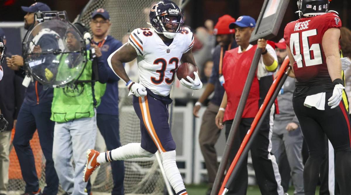 Bears cornerback Jaylon Johnson carries a ball after recovering a football in a game vs. the Falcons.