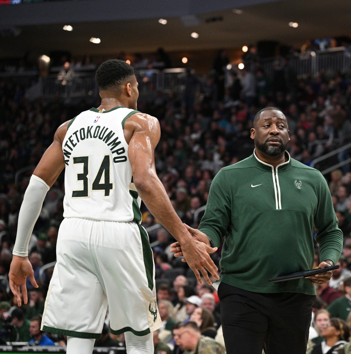  Milwaukee Bucks coach Adrian Griffin low fives Milwaukee Bucks forward Giannis Antetokounmpo (34) 