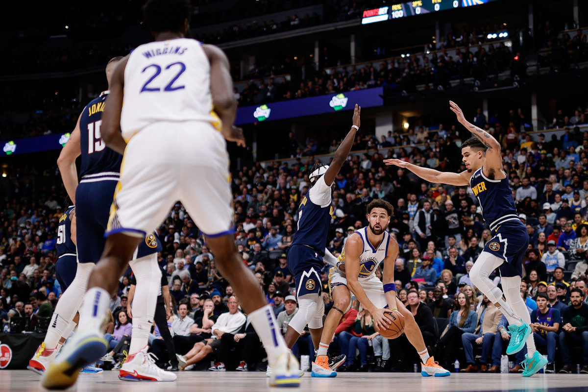 Golden State Warriors guard Klay Thompson controls the ball as Denver Nuggets guard Reggie Jackson and forward Michael Porter Jr. defend in the first quarter at Ball Arena.