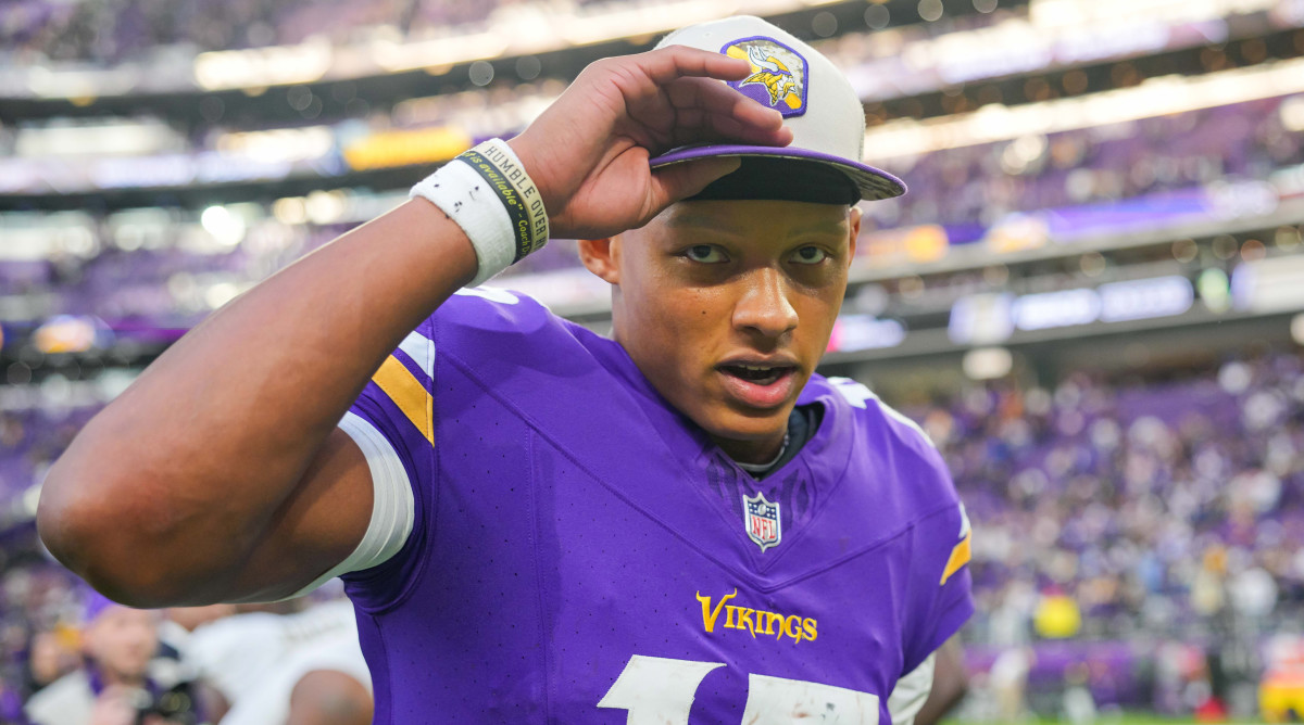 Joshua Dobbs puts a Vikings hat on after the game