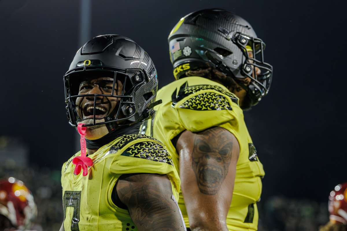 Oregon Ducks running back Bucky Irving celebrates with offensive lineman Steven Jones in a game against the USC Trojans.