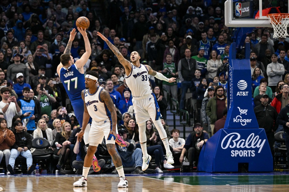 Mavs' Luka Doncic shoots a fadeaway jumper over Wizards' Kyle Kuzma.