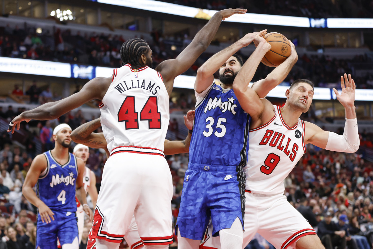 Orlando Magic center Goga Bitadze (35) battles for the ball with Chicago Bulls forward Patrick Williams (44) and center Nikola Vucevic (9) during the second half at United Center.