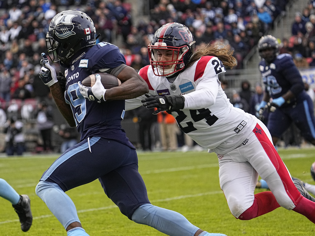 Nov 13, 2022; Toronto, Ontario, CAN; Montreal Alouettes defensive back Marc-Antoine Dequoy (24) tries to tackle Toronto Argonauts wide receiver Kurleigh Gittens Jr. (19) after a pass reception during the first half at BMO Field. Mandatory Credit: John E. Sokolowski-USA TODAY Sports