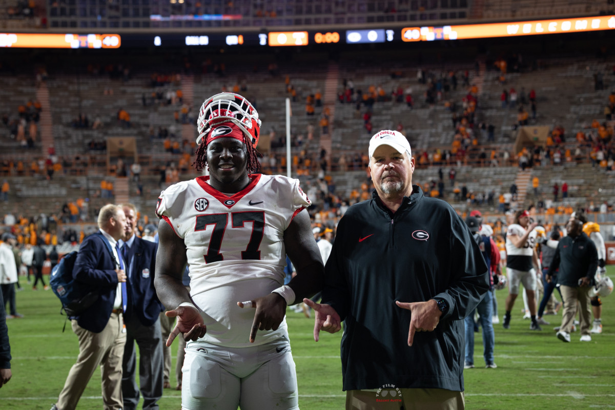 Georgia Bulldogs OT Amarius Mims (77), and OL coach Stacy Searels (right), posing together following win over Tennessee on Nov. 18, 2023. (Brooks Austin / Dawgs Daily).