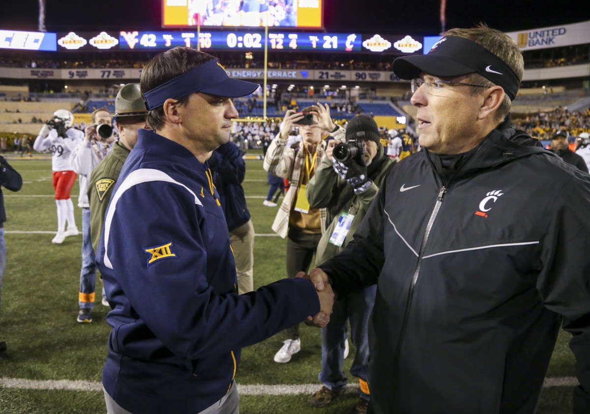 Nov 18, 2023; Morgantown, West Virginia, USA; West Virginia Mountaineers head coach Neal Brown talks with Cincinnati Bearcats head coach Scott Satterfield after the game at Mountaineer Field at Milan Puskar Stadium.