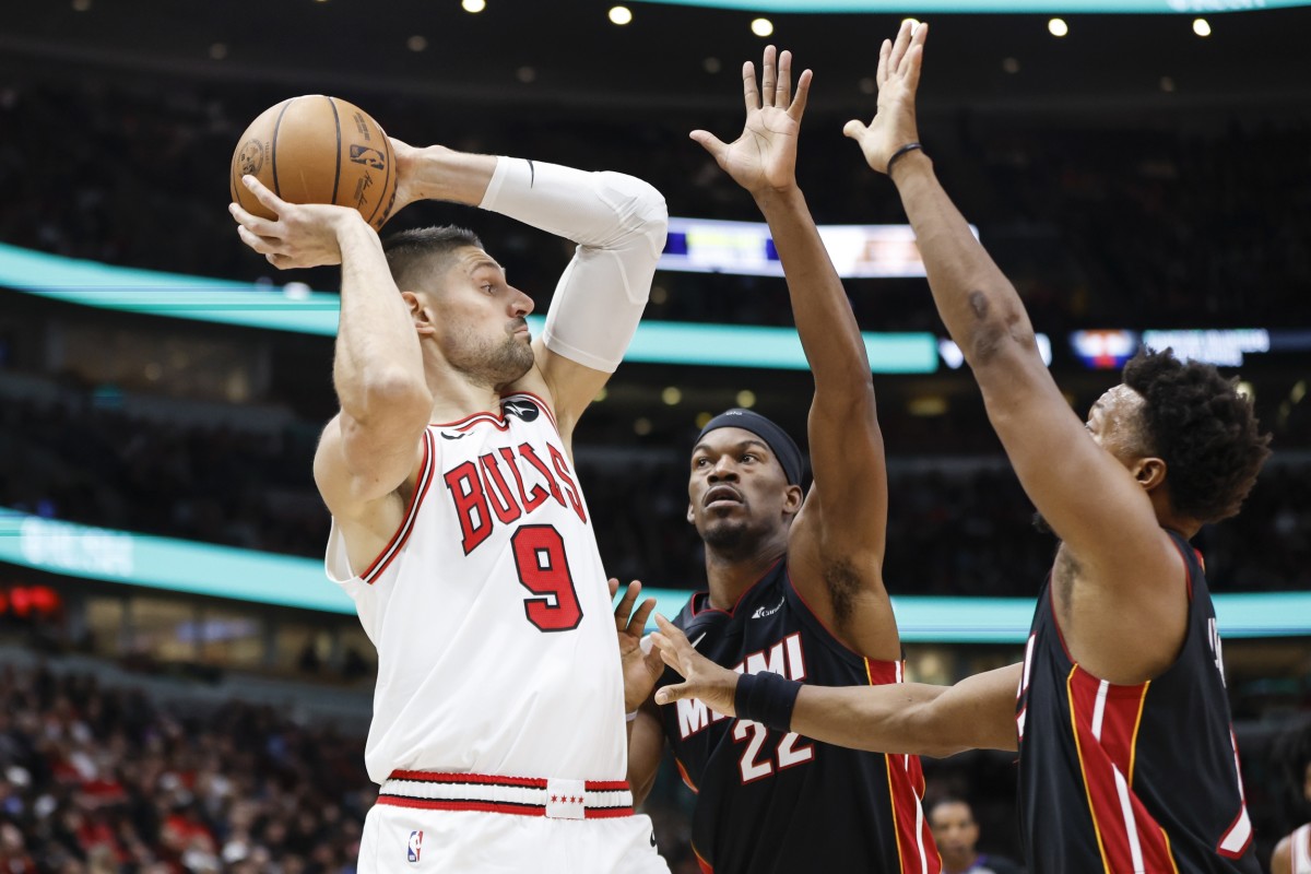 Chicago Bulls center Nikola Vucevic (9) looks to pass the ball against Miami Heat forward Jimmy Butler (22) and guard Kyle Lowry (7) during the first half at United Center.