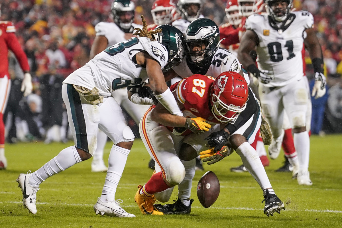 Kansas City Chiefs tight end Travis Kelce drops the ball while be taken down by Philadelphia Eagles cornerback Bradley Roby and linebacker Zach Cunningham at GEHA Field at Arrowhead Stadium.