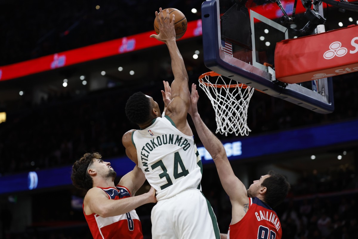 Milwaukee Bucks forward Giannis Antetokounmpo (34) dunks the ball over Washington Wizards forward Danilo Gallinari (88) and Wizards forward Deni Avdija (8) 