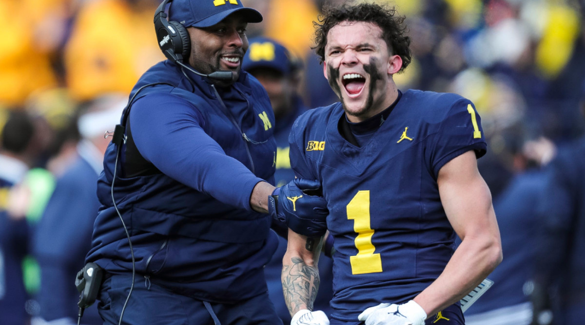 Michigan WR Roman Wilson flexes after play against Ohio State.