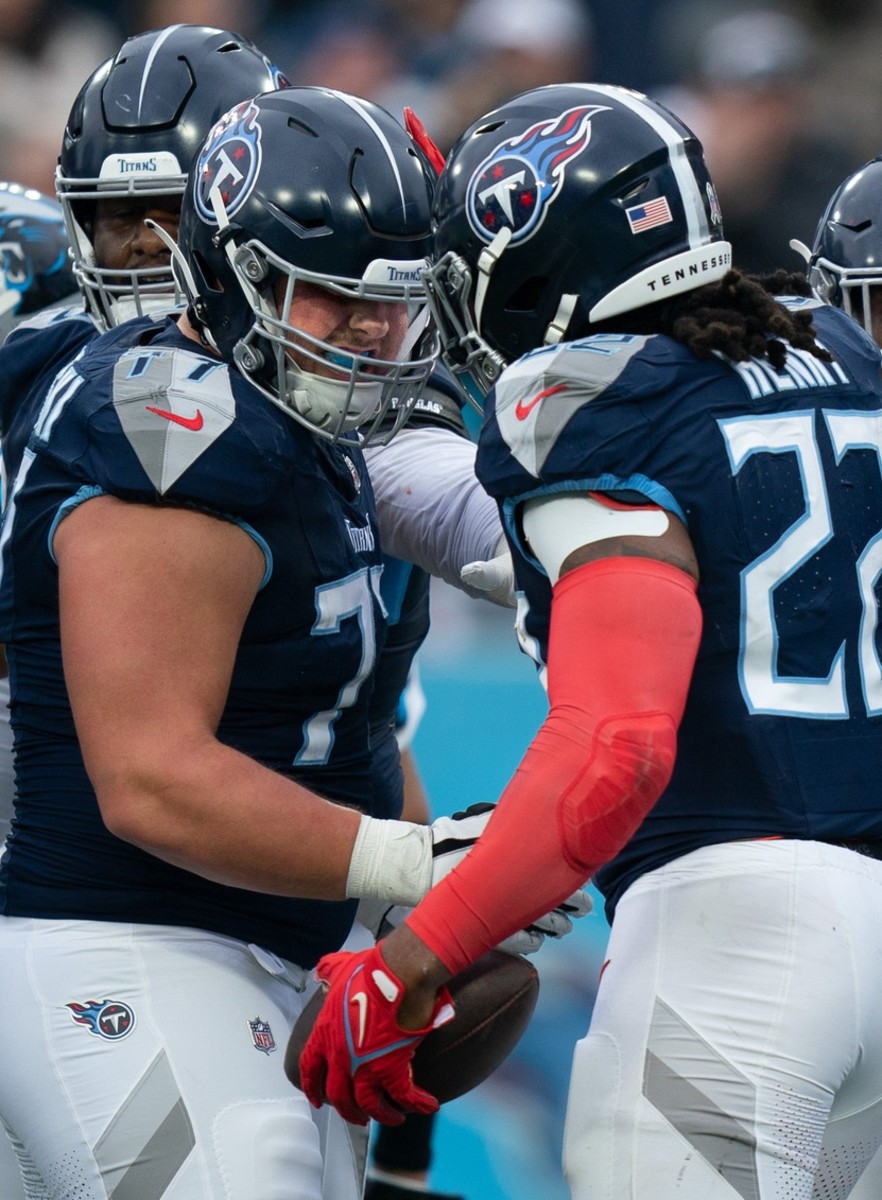 Tennessee Titans offensive tackle Peter Skoronski (77) and running back Derrick Henry (22) celebrate Henry's touchdown with a head butt in the second quarter of their game against Carolina Panthers.