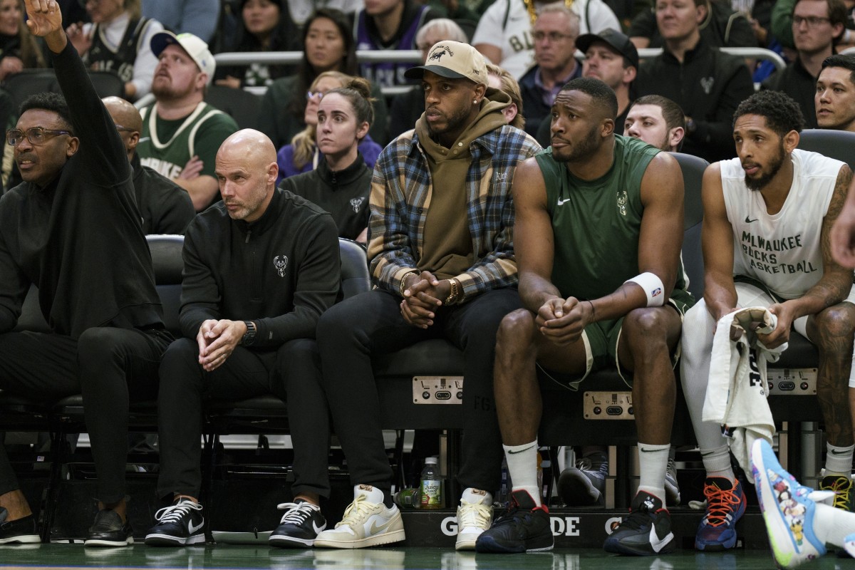 Milwaukee Bucks forward Khris Middleton sits on the bench in street clothes 