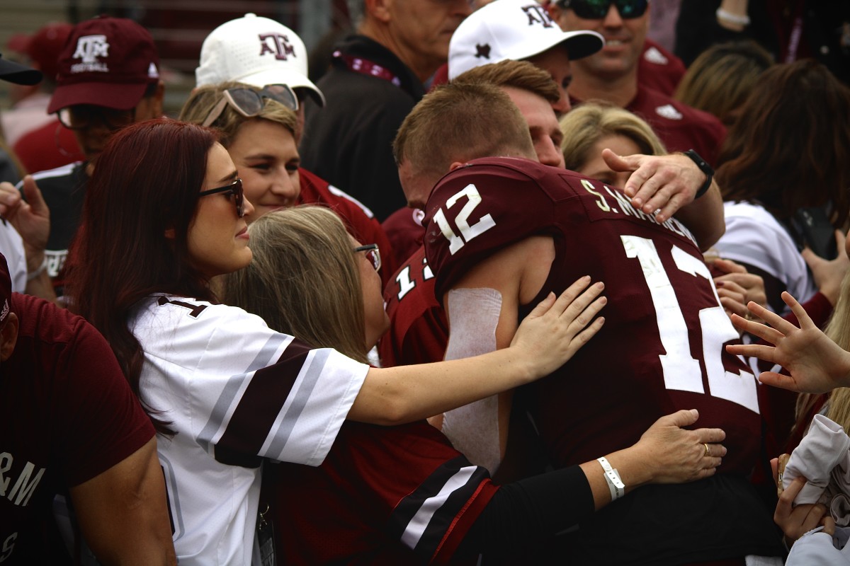 Texas A&M Aggies walk-on defensive back Sam Mathews embraces his family following the final home game of his career. He was given the honor of wearing No. 12 in honor of Texas A&M's long standing tradition of The 12th Man.