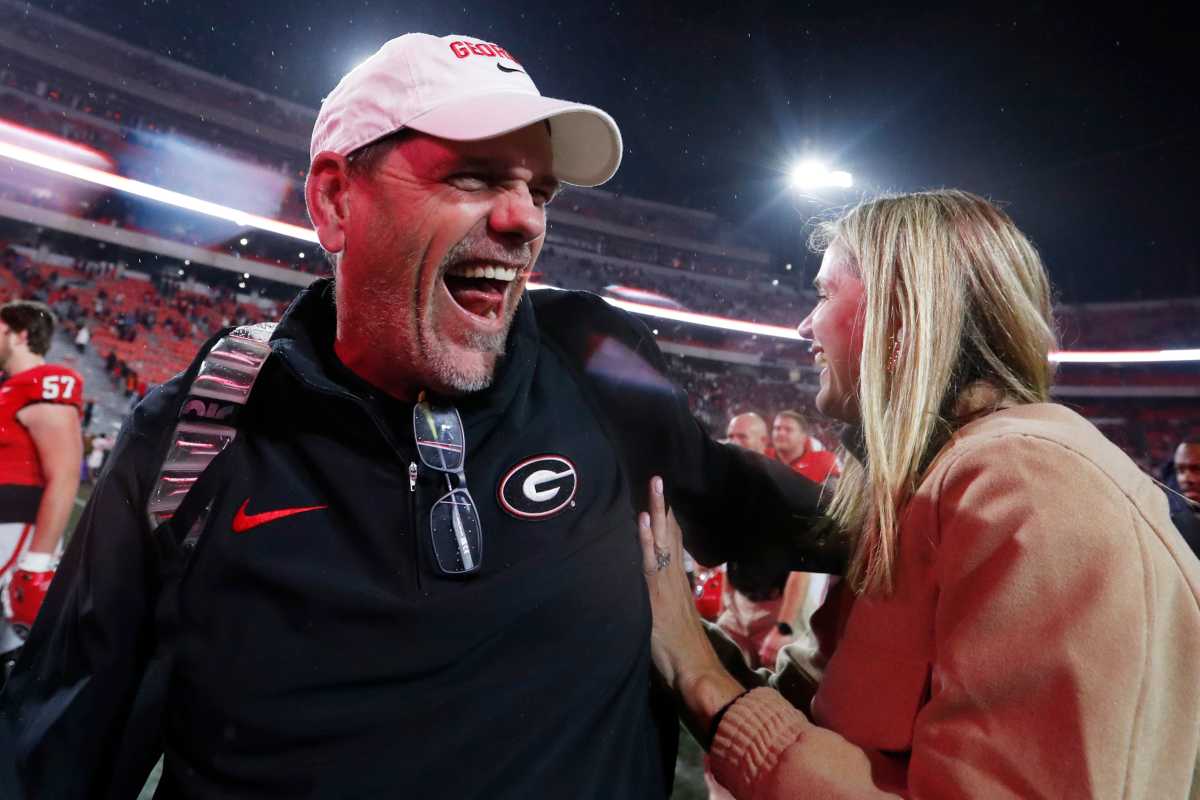 Georgia Offensive Coordinator Mike Bobo celebrates with Mary Beth Smart after wining a NCAA college football game against Ole Miss in Athens, Ga., on Saturday, Nov. 11, 2023. Georgia won 52-17.