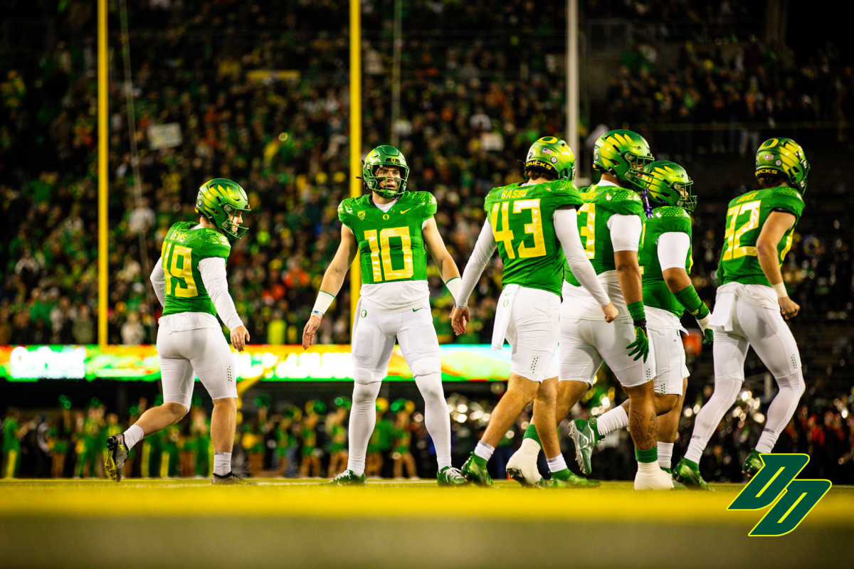 Oregon Ducks quarterback Bo Nix high-fives teammates in a game against the Oregon State Beavers.