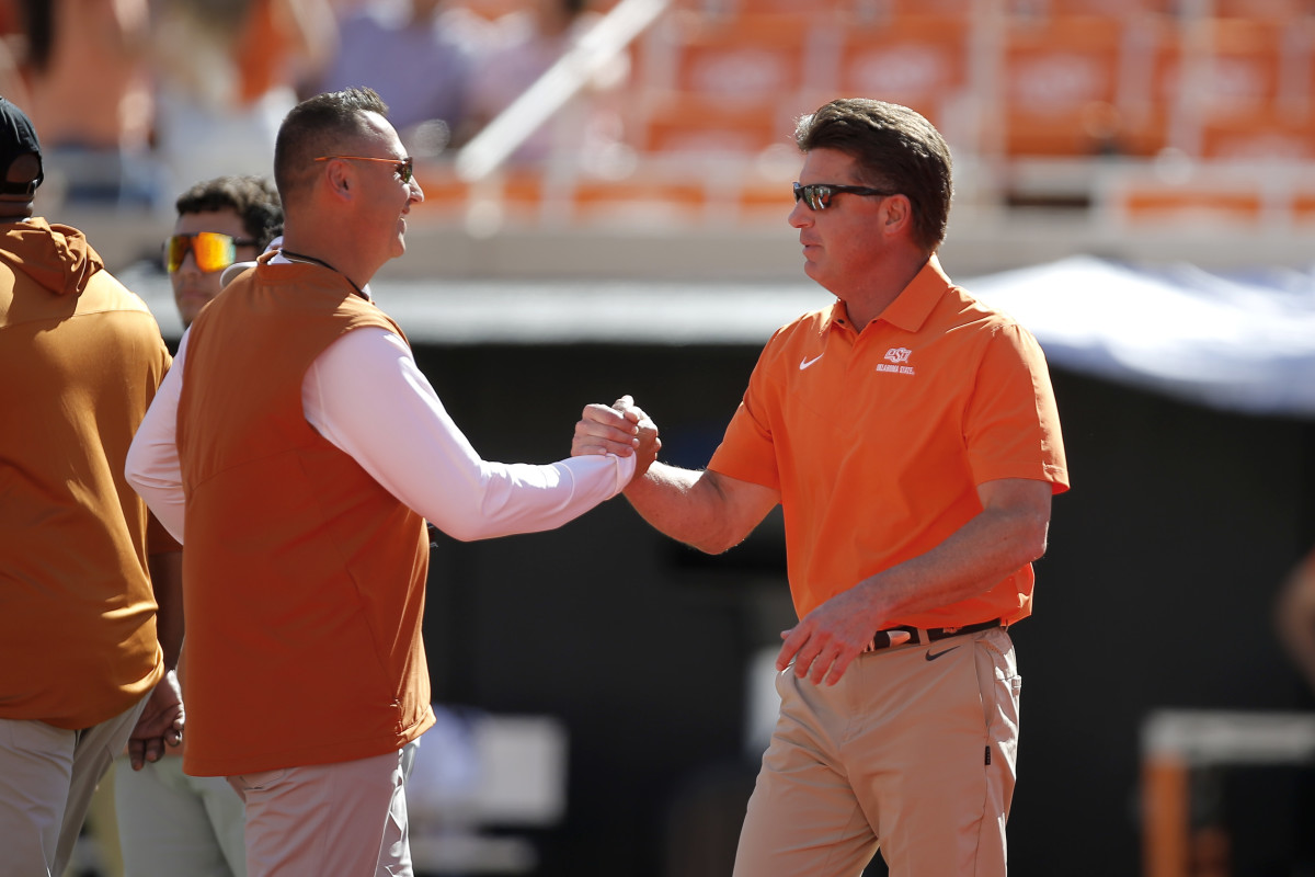 Texas Longhorns head coach Steve Sarkisian, left, and Oklahoma State Cowboys head coach Mike Gundy talk before a college football game between the Oklahoma State Cowboys (OSU) and the University of Texas at Austin Longhorns. 