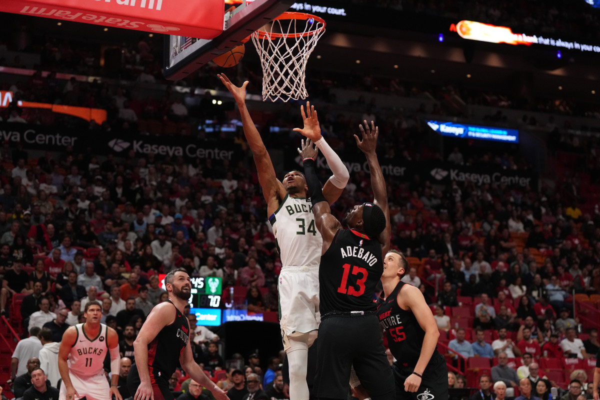 Milwaukee Bucks star Giannis Antetokounmpo shoots the ball while being defended by Miami Heat center Bam Adebayo during the second half at Kaseya Center.