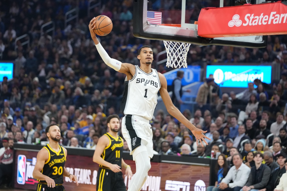 San Antonio Spurs center Victor Wembanyama (1) dunks the basketball against Golden State Warriors guard Stephen Curry (30) and guard Klay Thompson (11) during the first quarter at Chase Center.