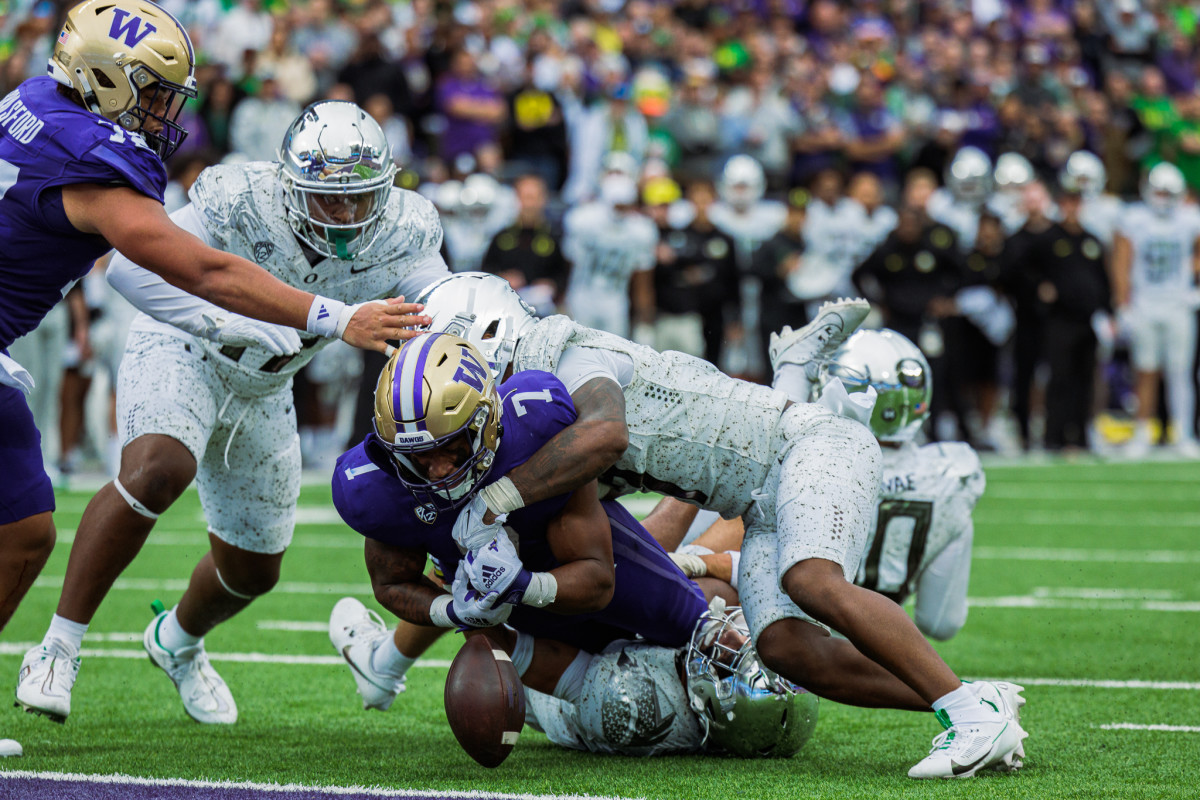 Oregon Ducks safety Steve Stephens IV tackles Washington Huskies running back Dillon Johnson.