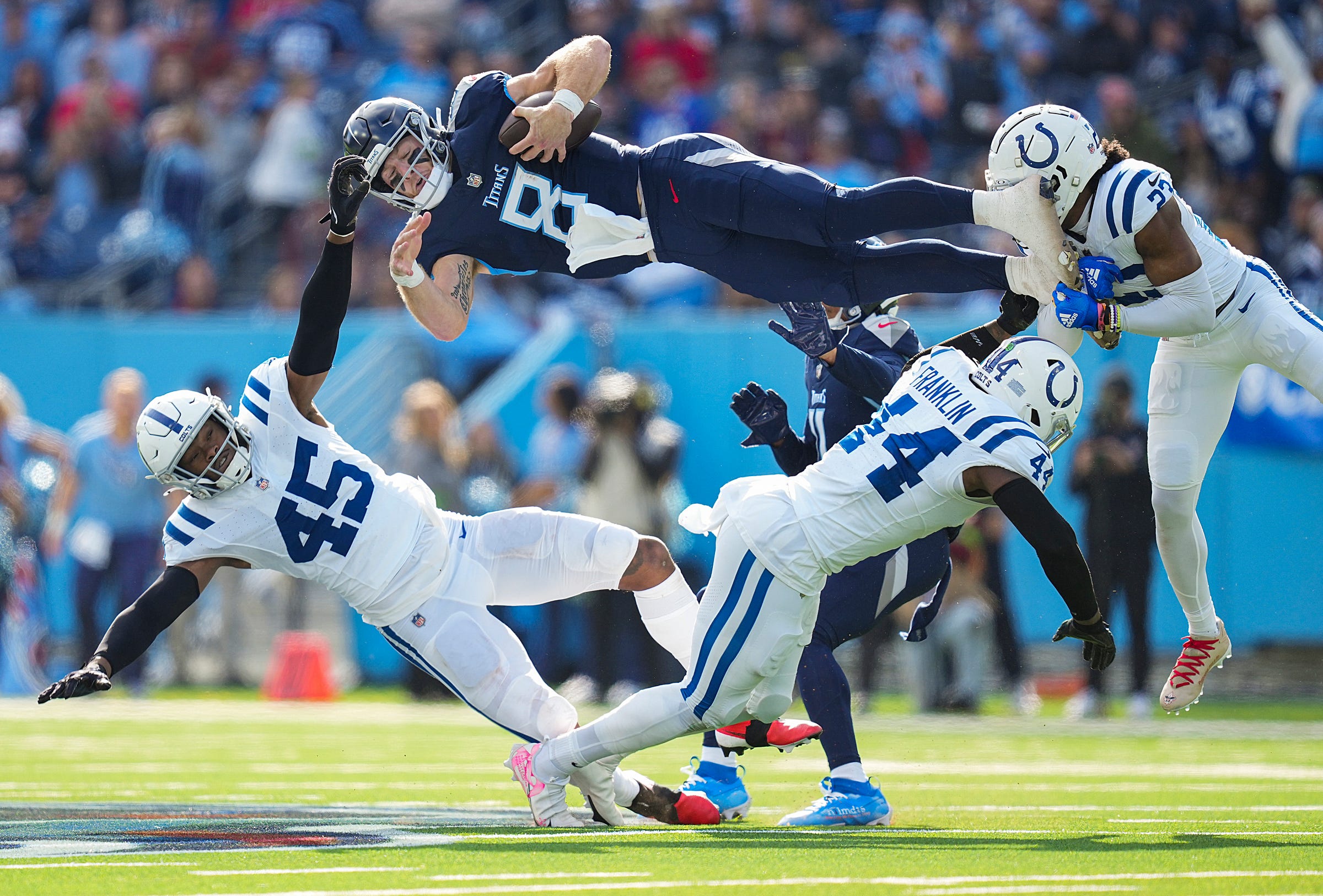 Tennessee Titans quarterback Will Levis (8) scrambles and jumps over Indianapolis Colts linebacker E.J. Speed (45), linebacker Zaire Franklin (44) and cornerback Kenny Moore II (23), on Sunday, Dec. 3, 2023, during NFL week 13 at Nissan Stadium in Nashville, Tenn.  