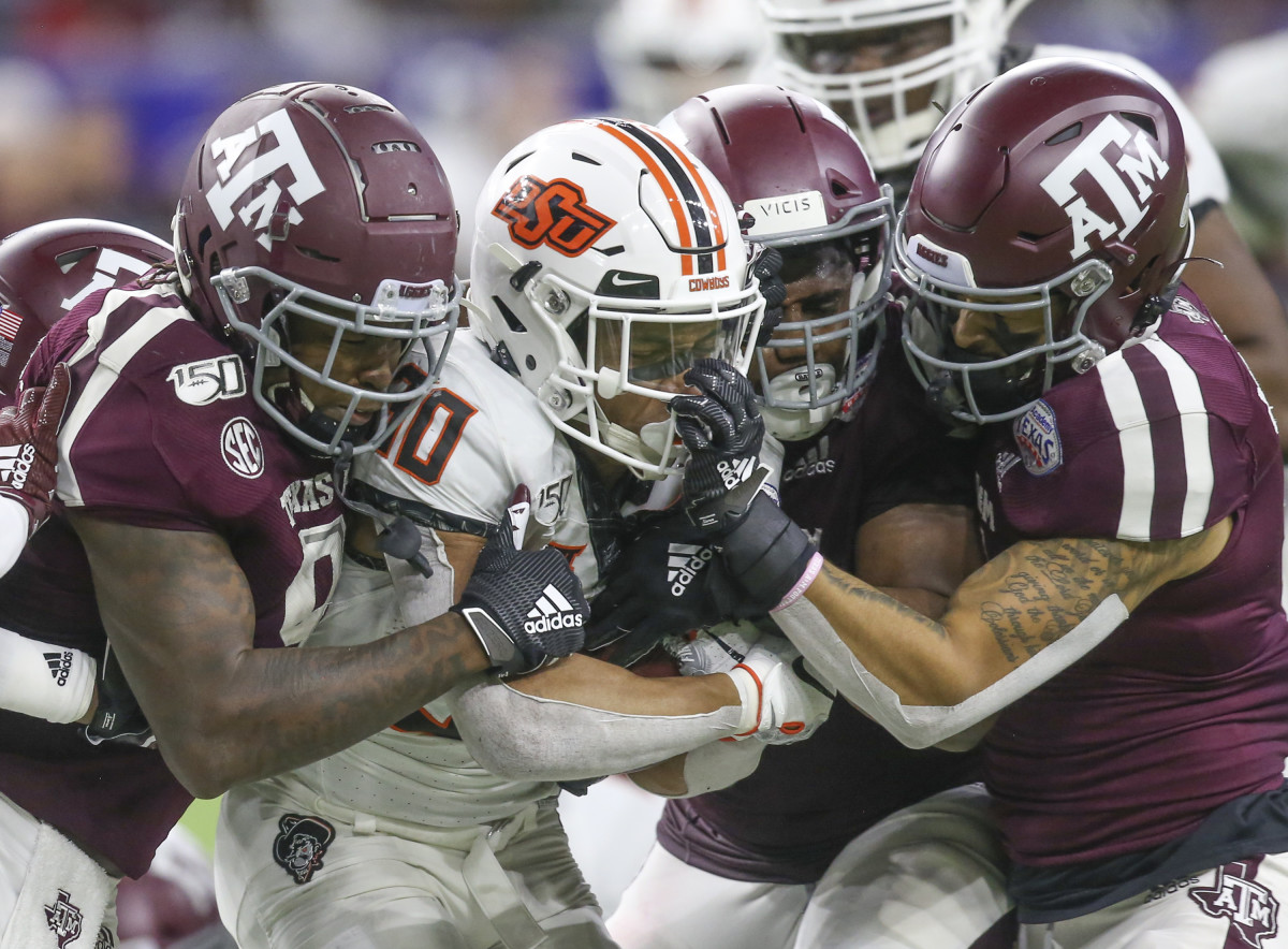 Oklahoma State Cowboys running back Chuba Hubbard (30) is face masked by Texas A&M Aggies defensive back Devin Morris (7) in the fourth quarter at NRG Stadium.