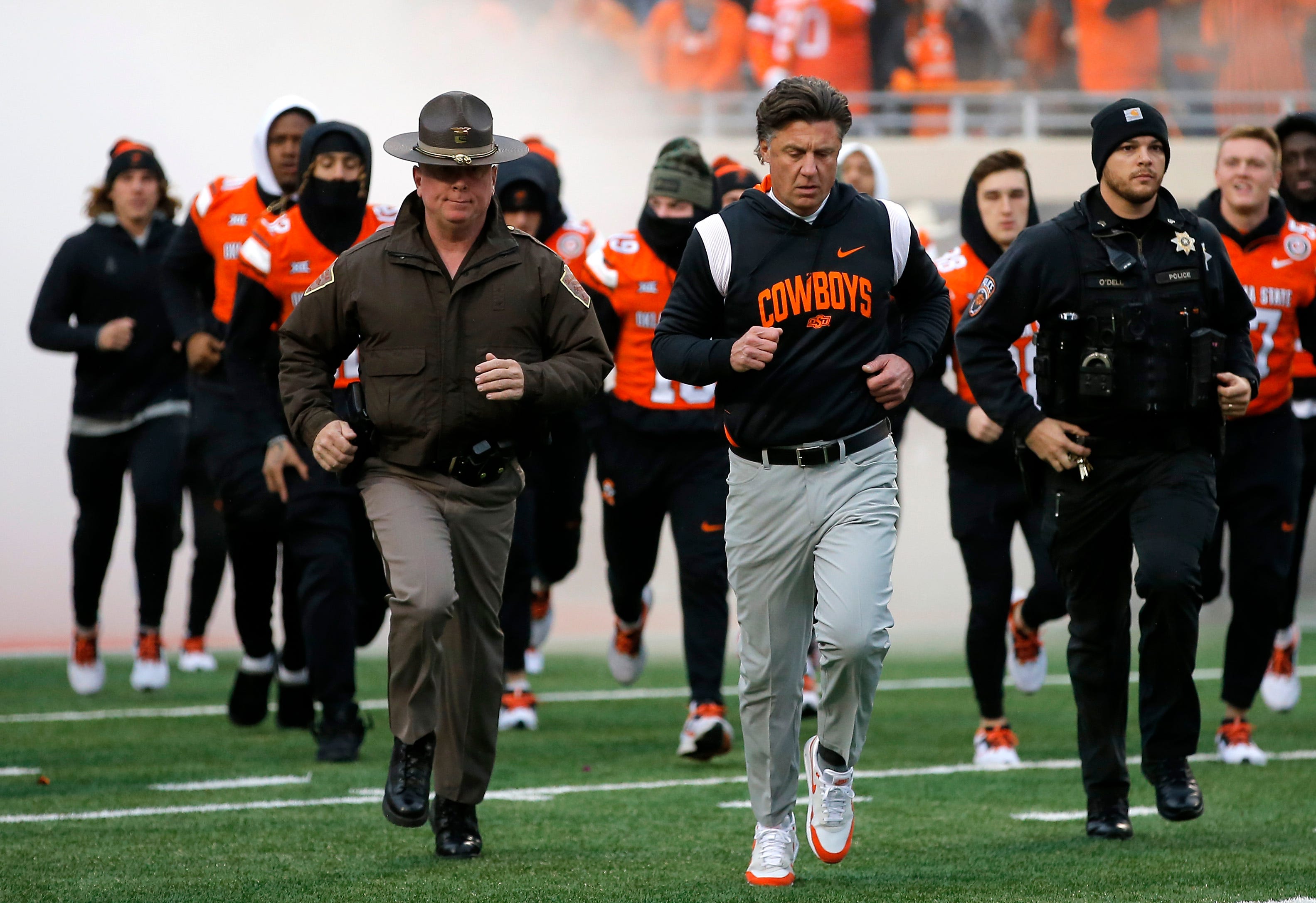 Oklahoma State head coach Mike Gundy runs on to the field before the college football game between the Oklahoma State University Cowboys and the Brigham Young Cougars at Boone Pickens Stadium in Stillwater, Okla., Saturday, Nov., 25, 2023. 