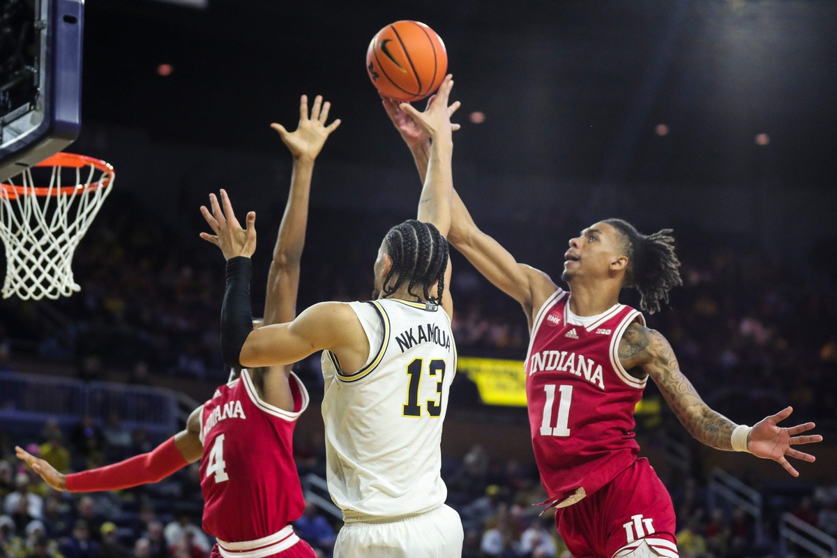 Indiana guard CJ Gunn, right, blocks a jump shot from Michigan forward Olivier Nkamhoua during the second half of Michigan's 78-75 loss on Tuesday, Dec. 5, 2023, at Crisler Center.