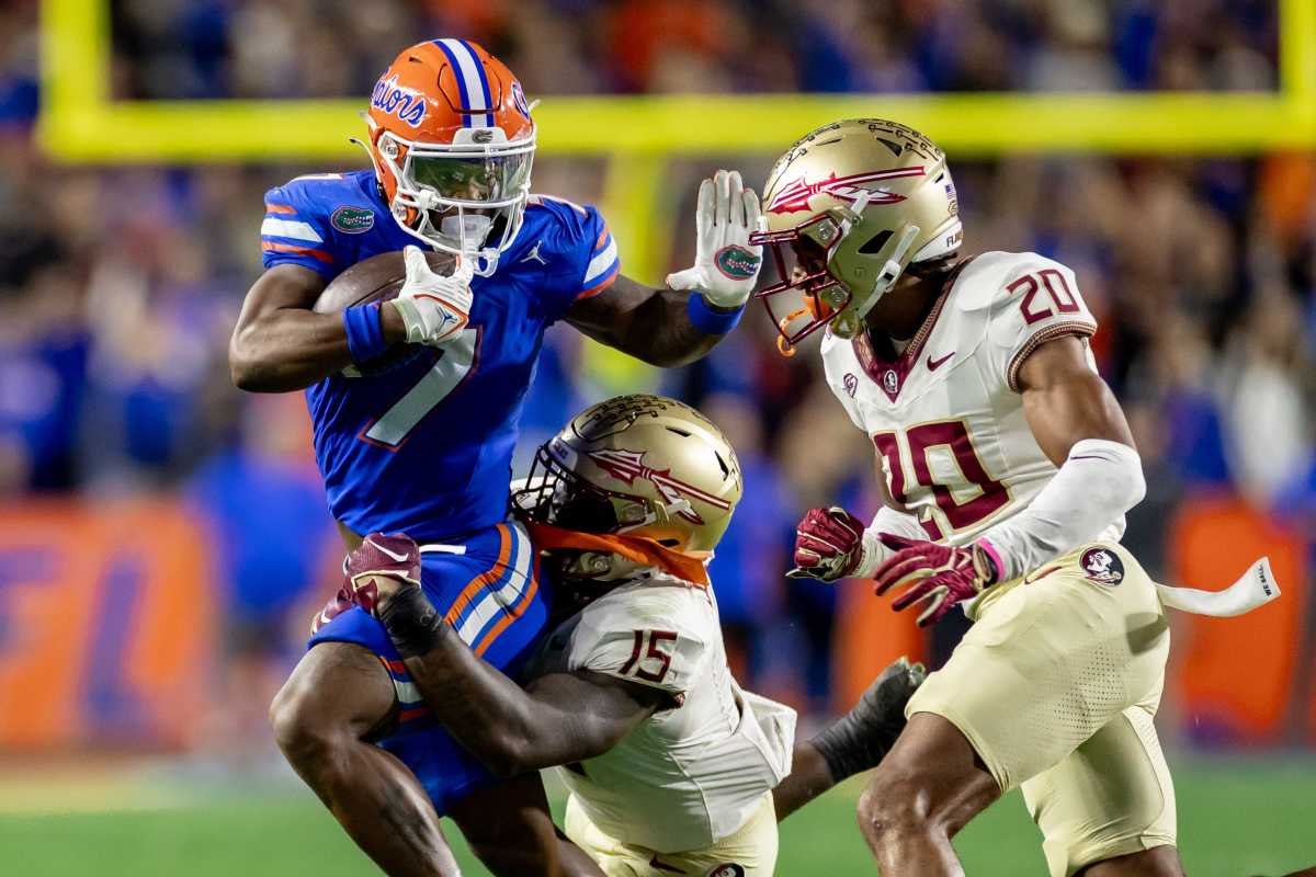 Florida Gators running back Trevor Etienne rushes with the ball while Florida State Seminoles linebacker Tatum Bethune and Florida State Seminoles defensive back Azareye'h Thomas attempt to tackle during the first half at Steve Spurrier Field at Ben Hill Griffin Stadium in Gainesville, FL on Saturday, November 25, 2023. [Matt Pendleton/Gainesville Sun]