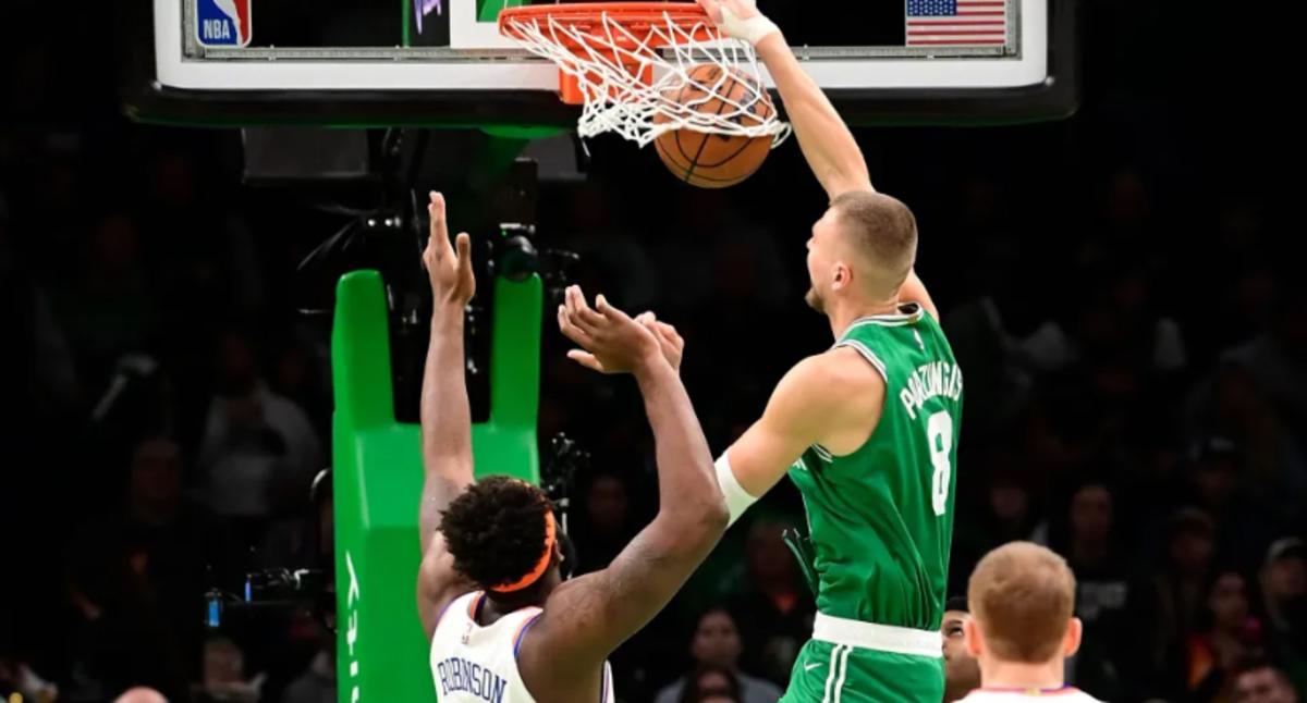 Kristaps Porzingis (in green) dunks over Mitchell Robinson during Friday night's game