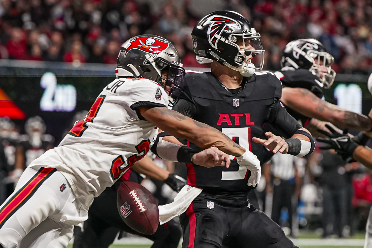 Atlanta Falcons quarterback Desmond Ridder fumbles amidst a hit from Tampa Bay Buccaneers safety Antoine Winfield Jr. on Dec. 10, 2023.