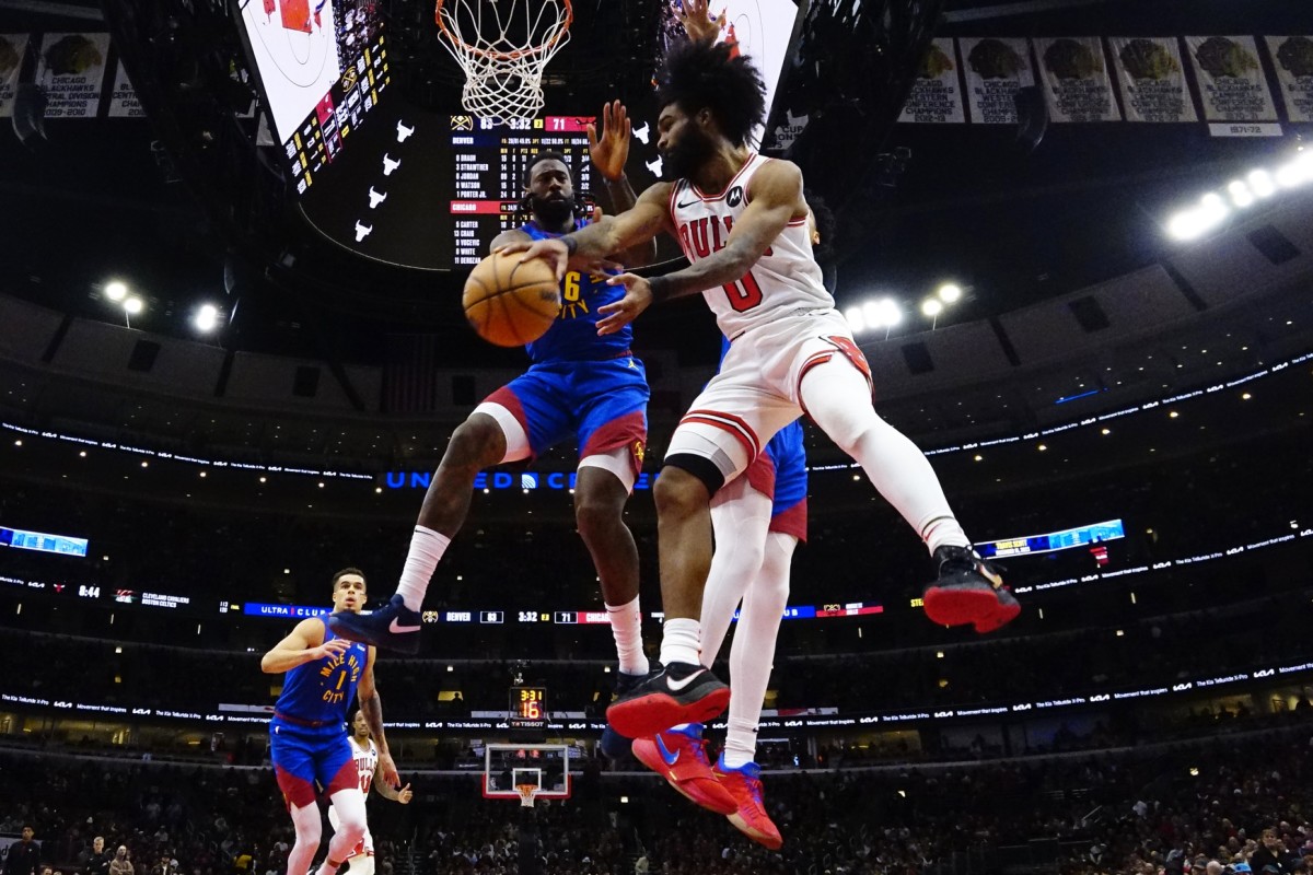 Chicago Bulls guard Coby White (0) looks to pass the ball around Denver Nuggets center DeAndre Jordan (6) during the second half at United Center