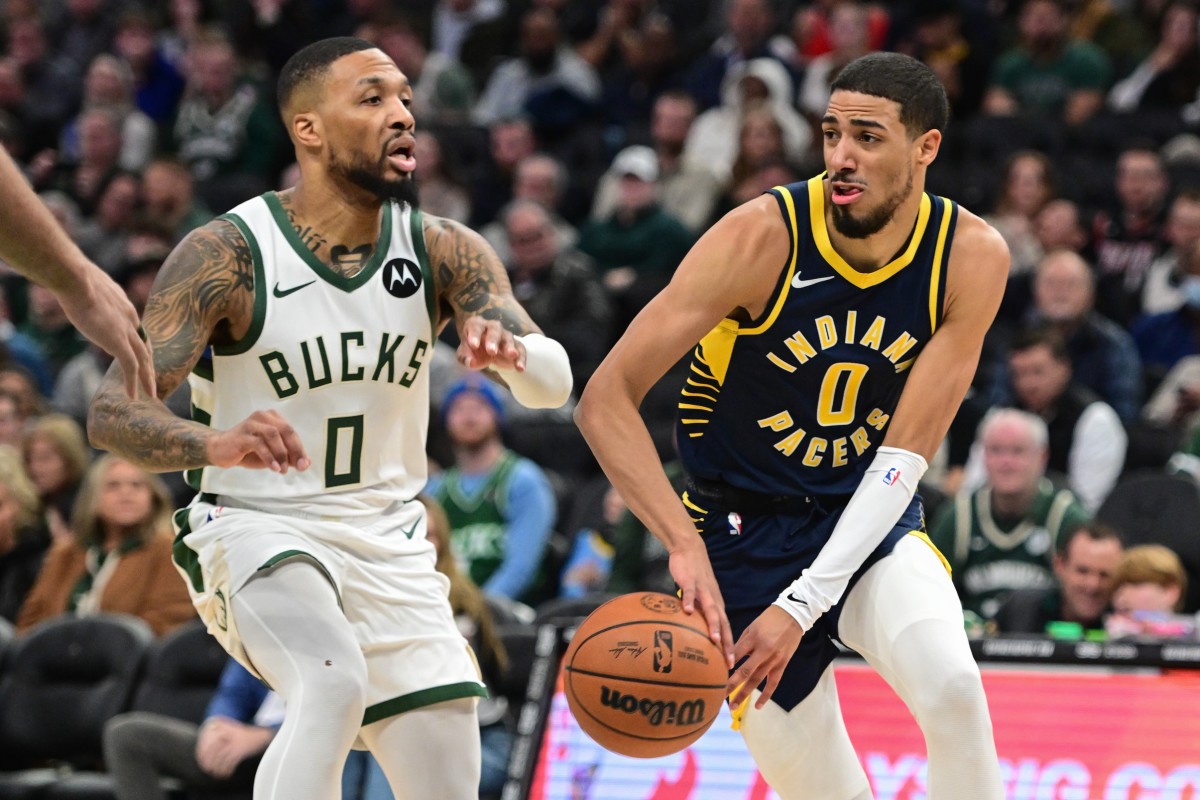 Indiana Pacers guard Tyrese Haliburton (0) passes the ball away from Milwaukee Bucks guard Damian Lillard (0) 