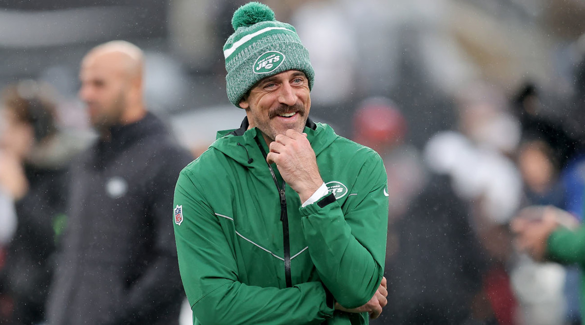 Aaron Rodgers watches Jets teammates warm up before a game against the Falcons.