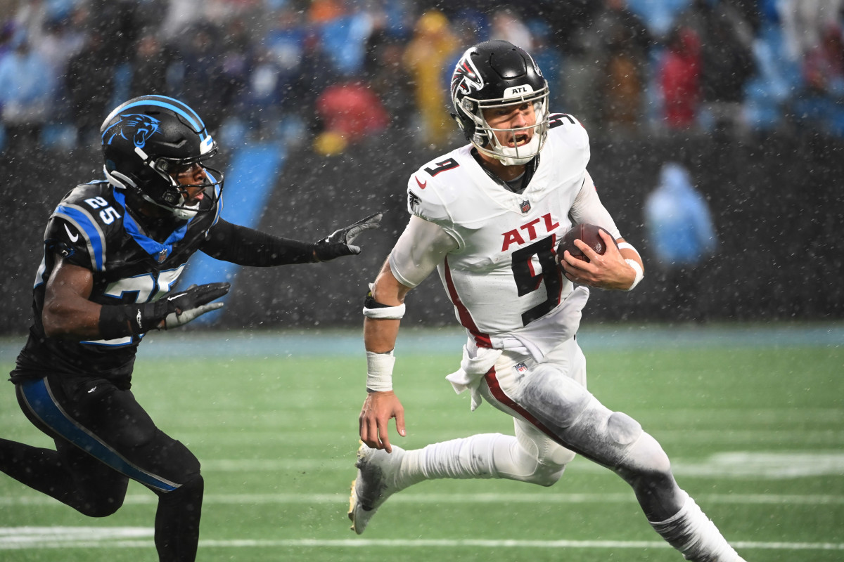 Dec 17, 2023; Charlotte, North Carolina, USA; Atlanta Falcons quarterback Desmond Ridder (9) runs as Carolina Panthers safety Xavier Woods (25) defends in the fourth quarter at Bank of America Stadium.