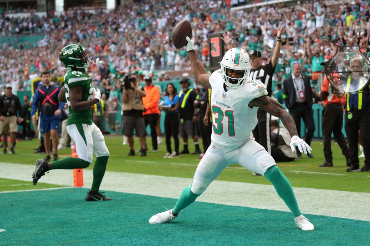 Miami Dolphins running back Raheem Mostert (31) spikes the ball after scoring a touchdown past New York Jets safety Tony Adams (22) during the first half of an NFL game at Hard Rock Stadium in Miami Gardens, Dec. 17, 2023.