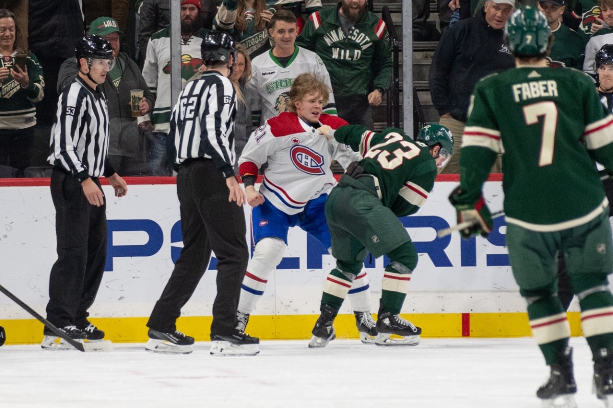 Dec 21, 2023; Saint Paul, Minnesota, USA; Minnesota Wild center Marco Rossi (23) and Montreal Canadiens defenseman Kaiden Guhle (21) fight in the second period at Xcel Energy Center.