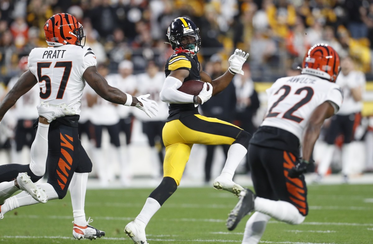 Dec 23, 2023; Pittsburgh, Pennsylvania, USA; Pittsburgh Steelers wide receiver George Pickens (14) runs on an eight-six yard touchdown reception as Cincinnati Bengals linebacker Germaine Pratt (57) and cornerback Chidobe Awuzie (22) chase during the first quarter at Acrisure Stadium. Mandatory Credit: Charles LeClaire-USA TODAY Sports  