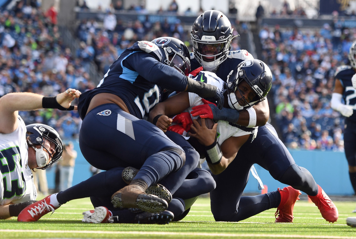 Seattle Seahawks quarterback Geno Smith (7) is sacked by Tennessee Titans defensive end Denico Autry (96) and linebacker Azeez Al-Shaair (2) during the first half at Nissan Stadium.