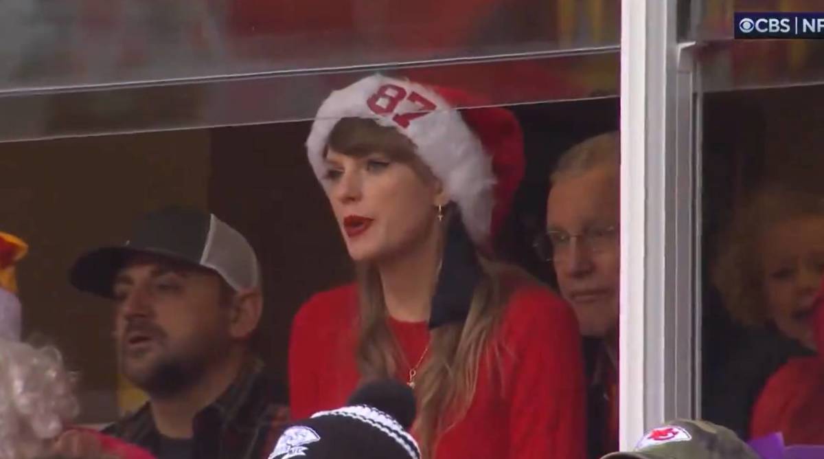 Taylor Swift watches Monday’s Chiefs-Raiders game from a suite while wearing a Christmas hat.