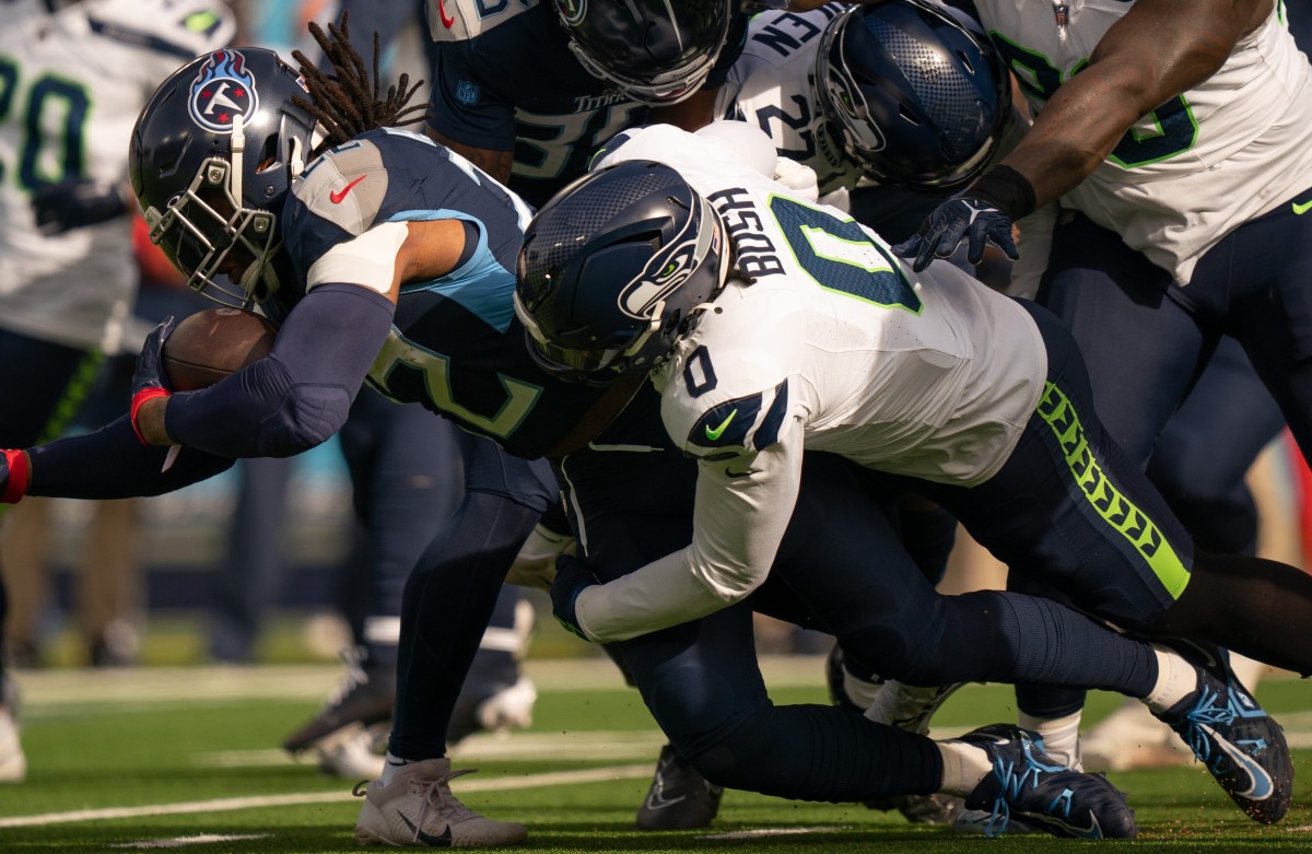 Tennessee Titans running back Derrick Henry (22) runs for a first down against Seattle Seahawks linebacker Devin Bush (0) during their game at Nissan Stadium in Nashville, Tenn.