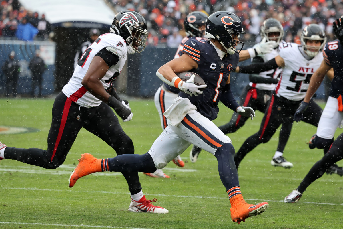 Dec 31, 2023; Chicago, Illinois, USA; Chicago Bears quarterback Justin Fields (1) rushes the ball past Atlanta Falcons defensive end Zach Harrison (96) during the first half at Soldier Field.