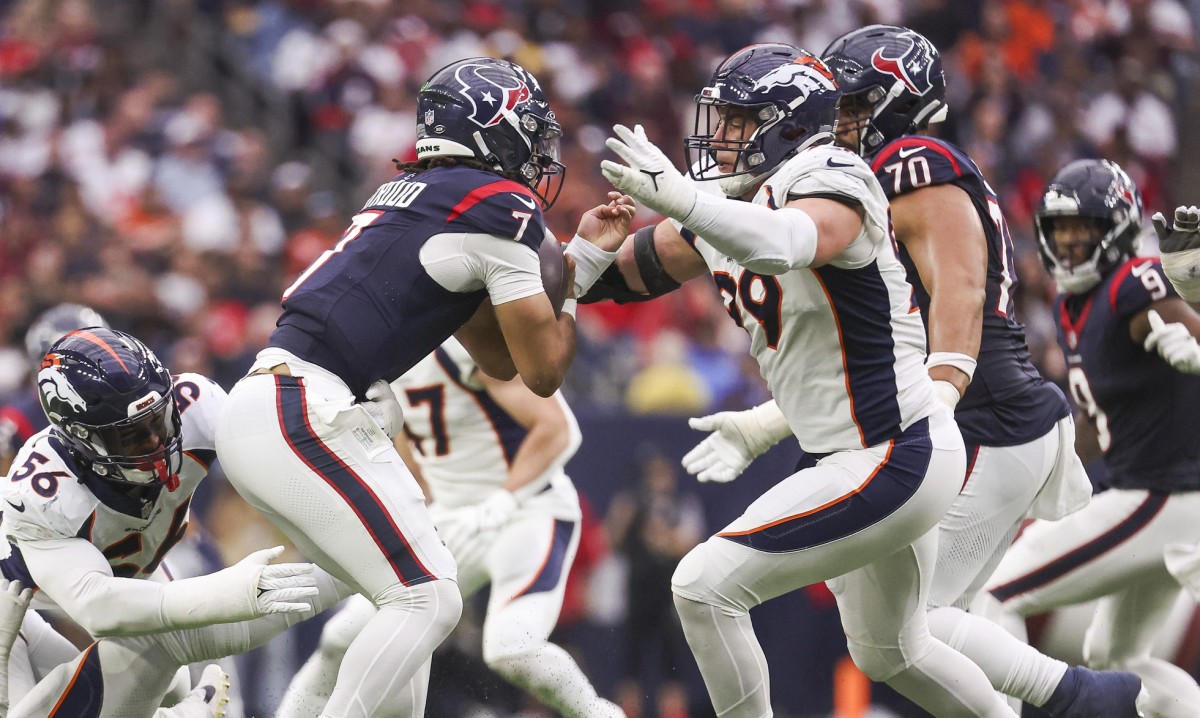 Dec 3, 2023; Houston, Texas, USA; Denver Broncos defensive end Zach Allen (99) attempts to tackle Houston Texans quarterback C.J. Stroud (7) during the game at NRG Stadium. Mandatory Credit: Troy Taormina-USA TODAY Sports  