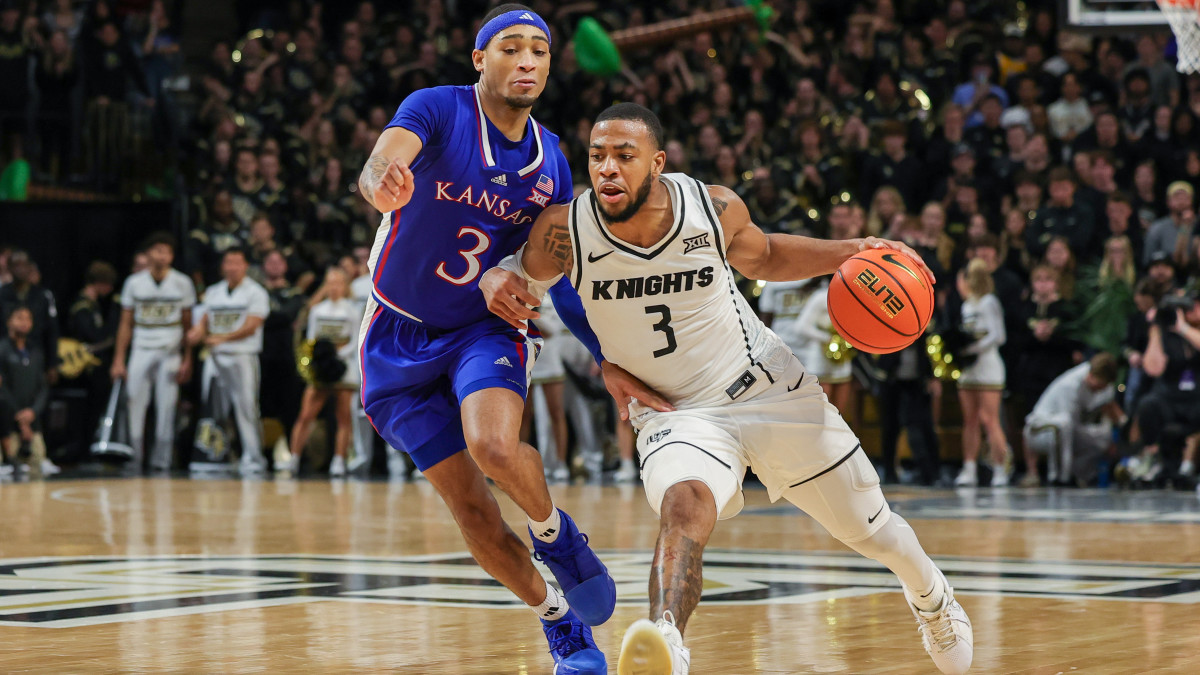 UCF Knights guard Darius Johnson drives around Kansas Jayhawks guard Dajuan Harris Jr.